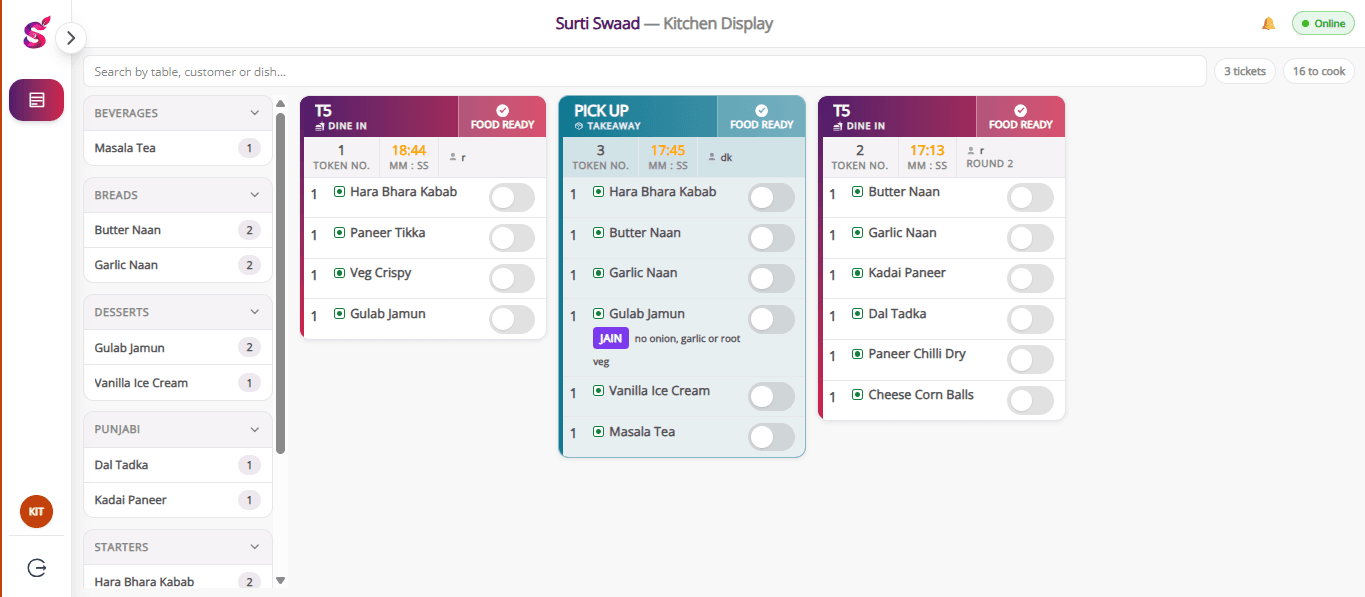 The kitchen display: three open tickets with timers, one marked round 2, and a Jain item flagged no onion, garlic or root veg.